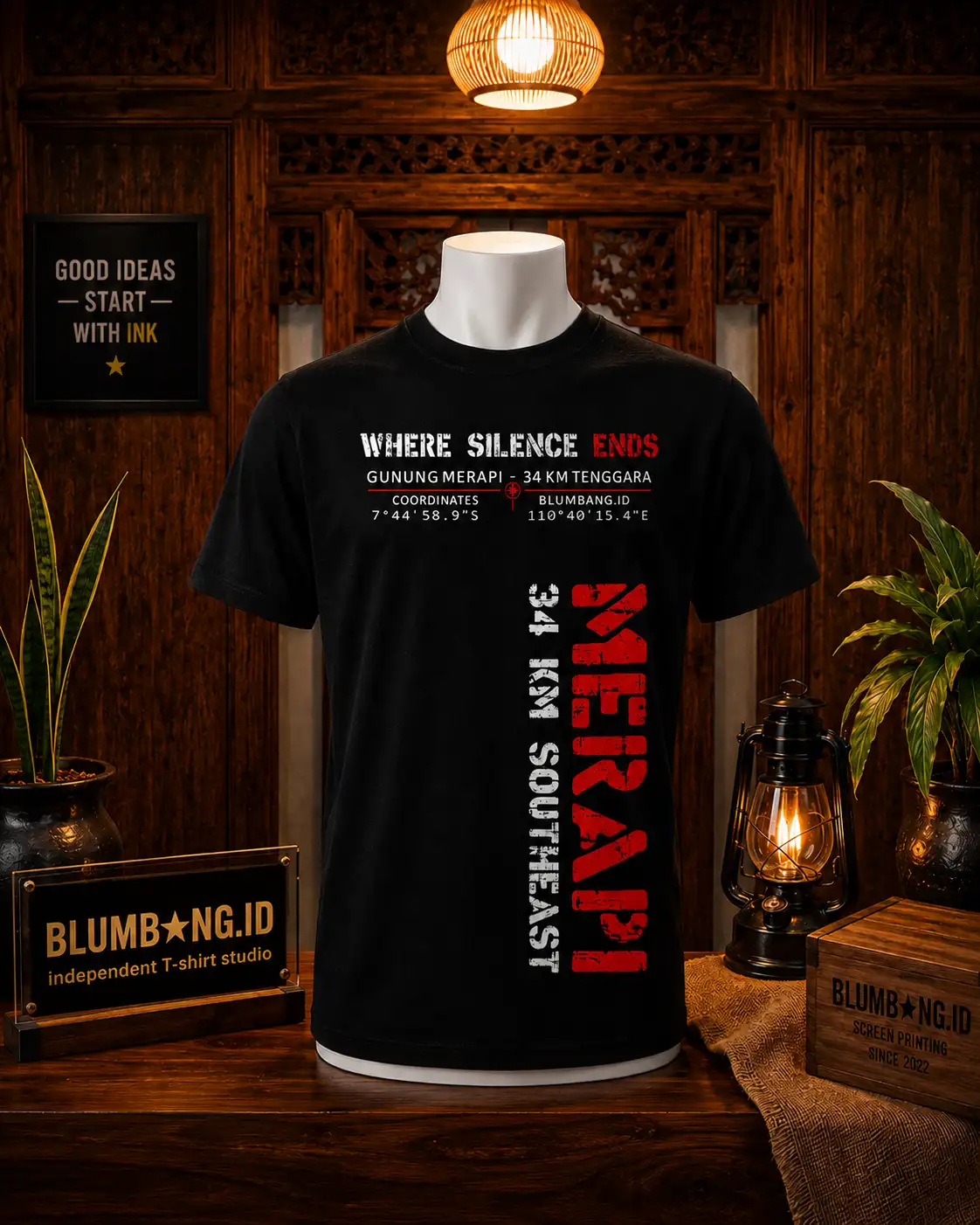 Kaos hitam dengan sablon distressed bertuliskan WHERE SILENCE ENDS, koordinat 7 derajat 44 menit 58.9 detik LS 110 derajat 40 menit 15.4 detik BT, dan tulisan MERAPI 34 KM SOUTHEAST vertikal warna merah putih di sisi kanan